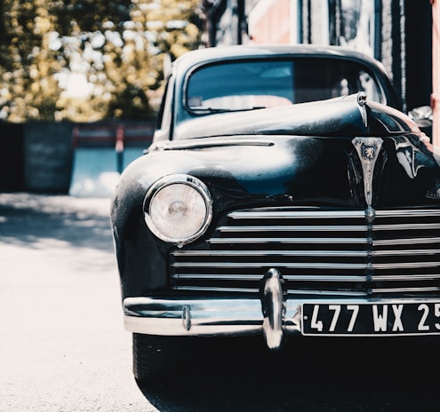 A vintage car parked in a scenic location, showcasing its timeless design.