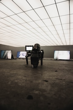 A futuristic film set with robotic cameras and LED walls displaying dynamic backgrounds.