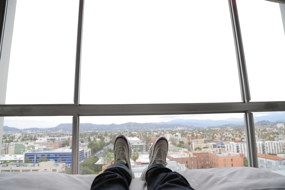 man lying on bed wearing black pants and white sneakers