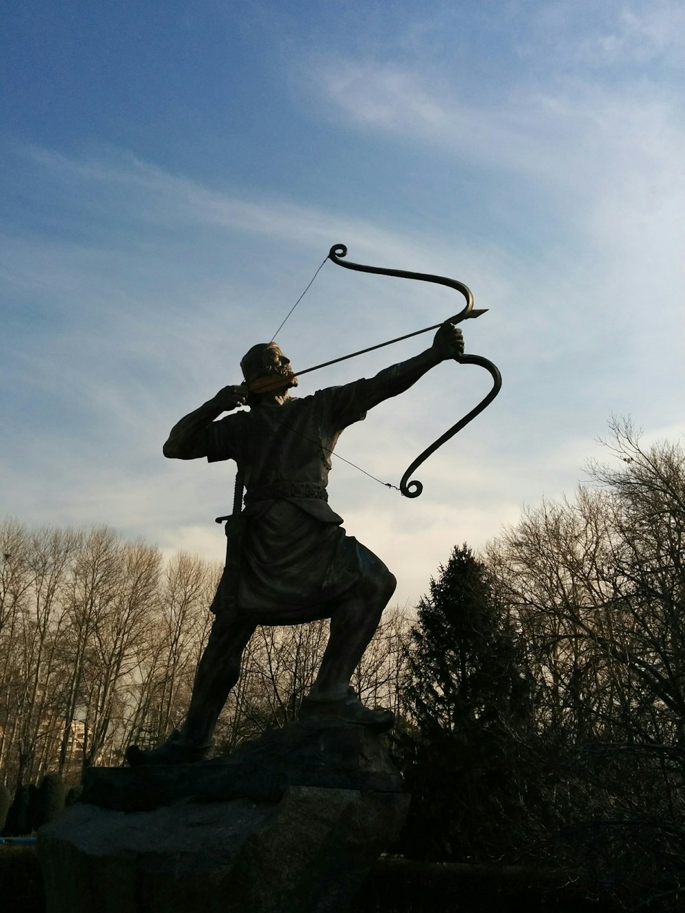 Homem segurando estátua do arqueiro