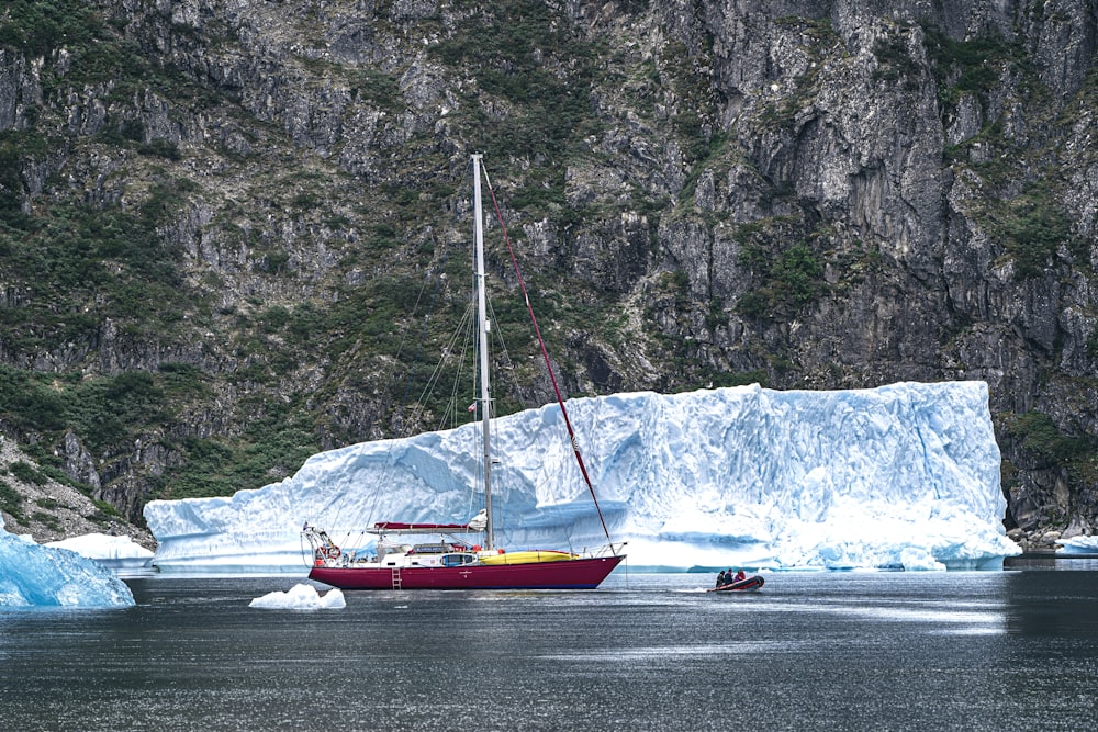 red boat on water beside ice berg