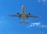 A commercial airplane is flying overhead against a bright blue sky with a few scattered clouds. The photograph captures the underbelly of the aircraft with its landing gear extended.