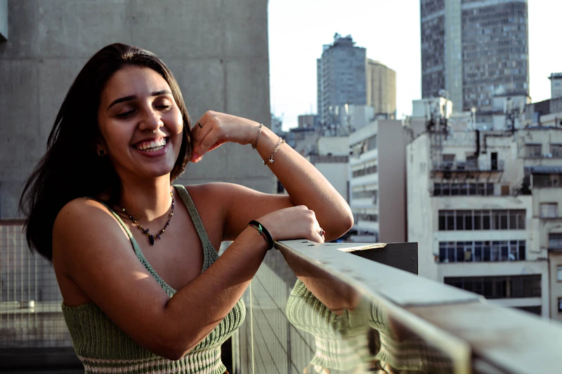 Sugar Mommy brasileira elegante, apoiada em guarda-corpo de vidro