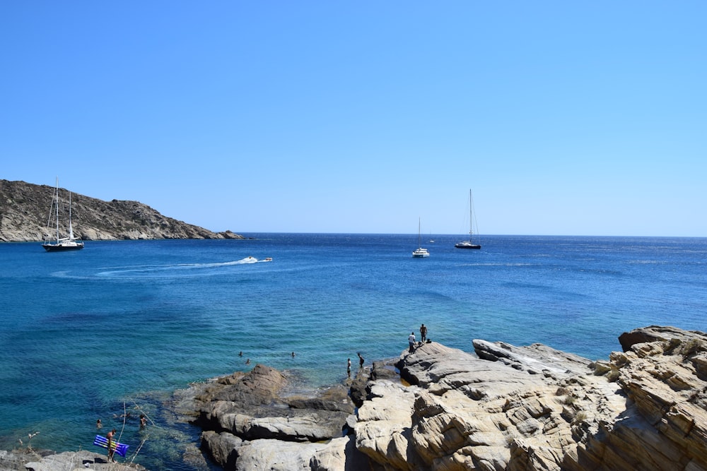 yachts anchored near rocky shore