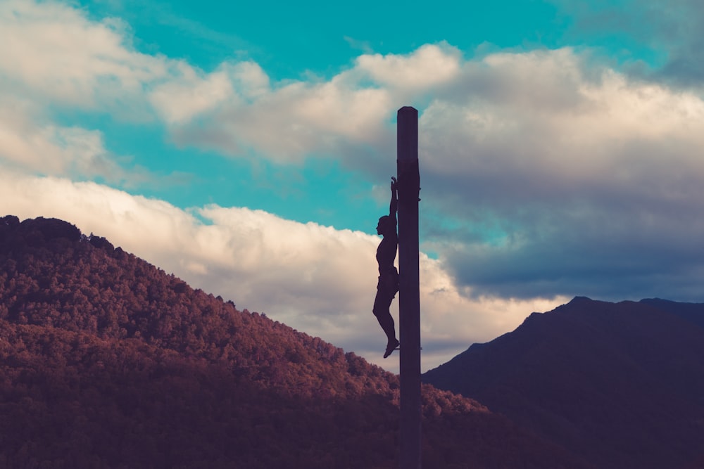 silhouette of crucified person during daytime