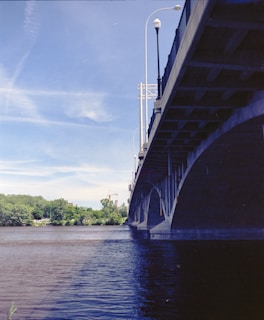 A large bridge spanning over a river during daytime construction.