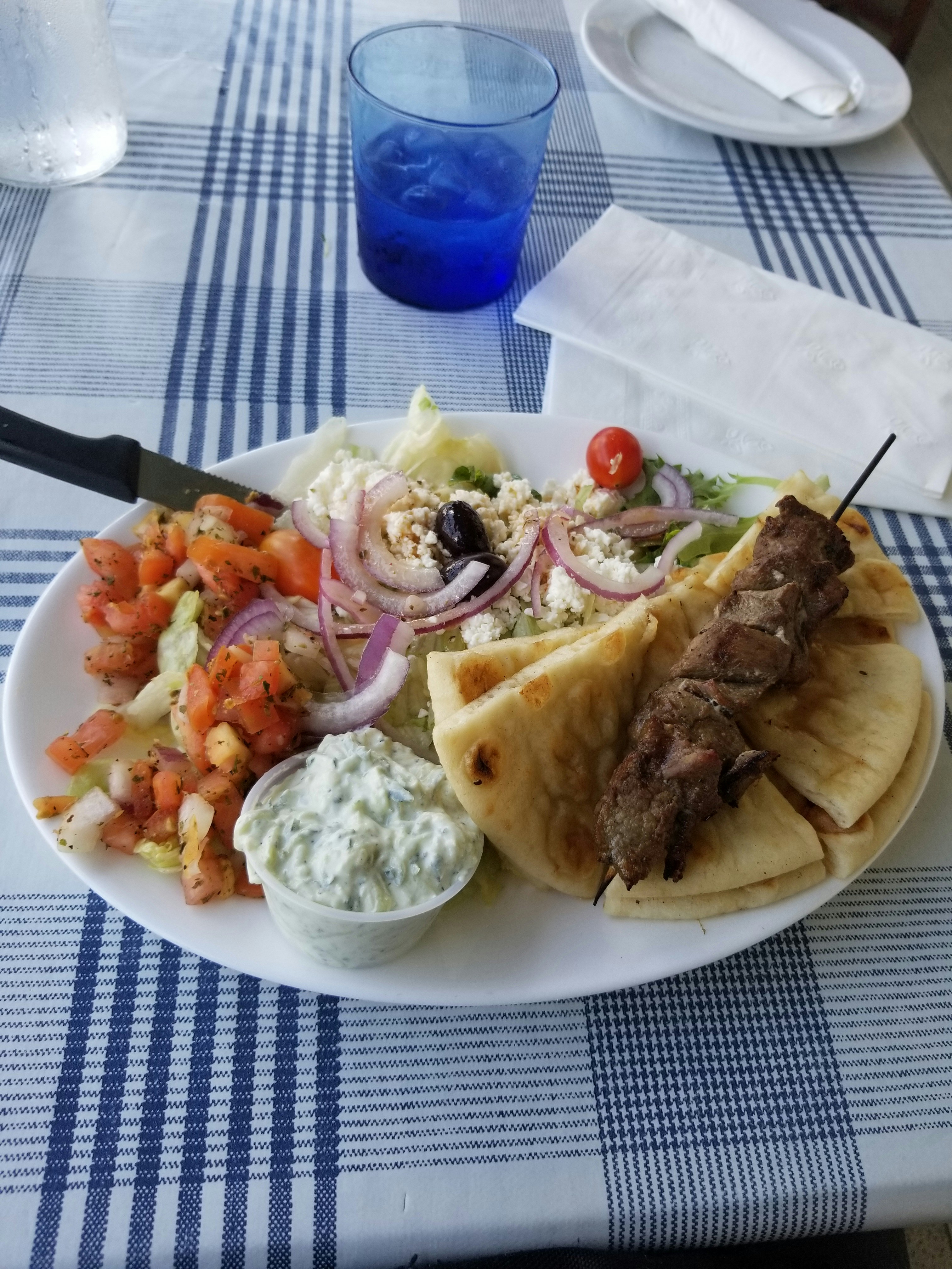 Gyro plate with tzatziki and pita bread, overhead view, warm tones