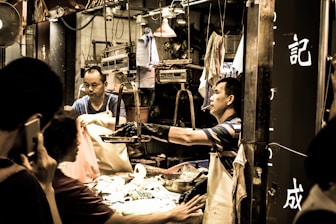 Close-up of hands exchanging promotional flyers at a busy market