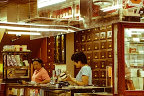 A cozy herbal shop counter with jars of natural remedies and a friendly staff member ready to assist.