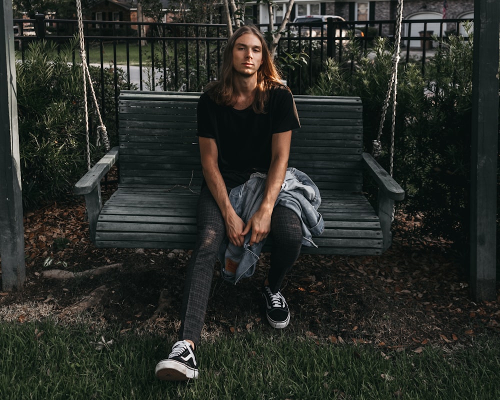 man sitting on swing bench