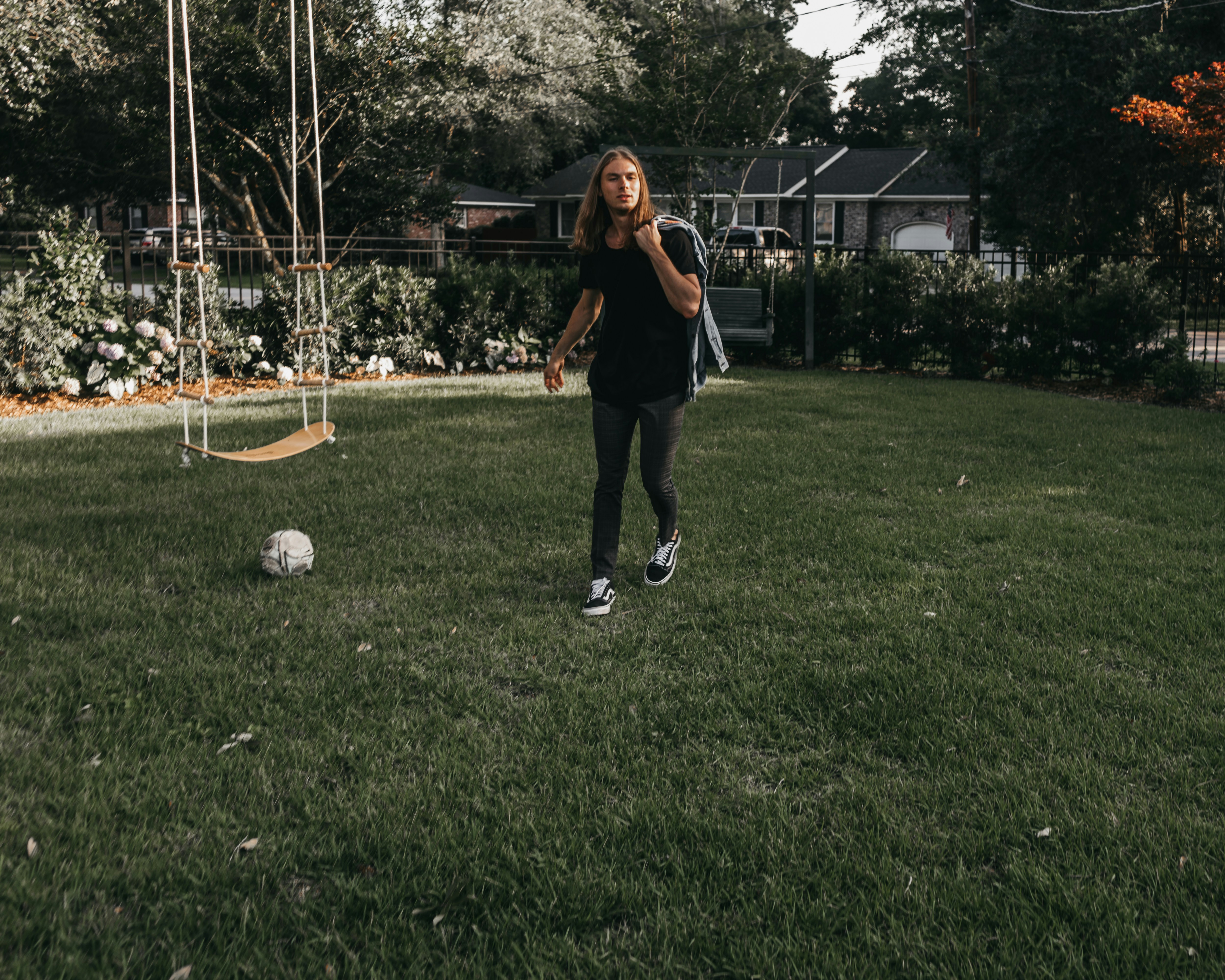 man wearing black shirt standing beside brown swign