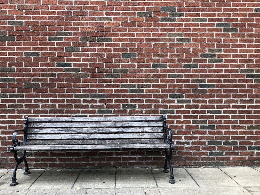 gray wooden bench beside brown wall