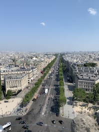 Aerial view of a city street with various vehicles in motion under clear weather.