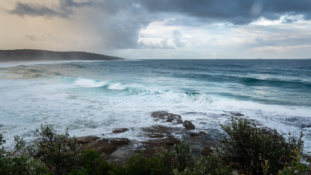 a large body of water near a rocky shore