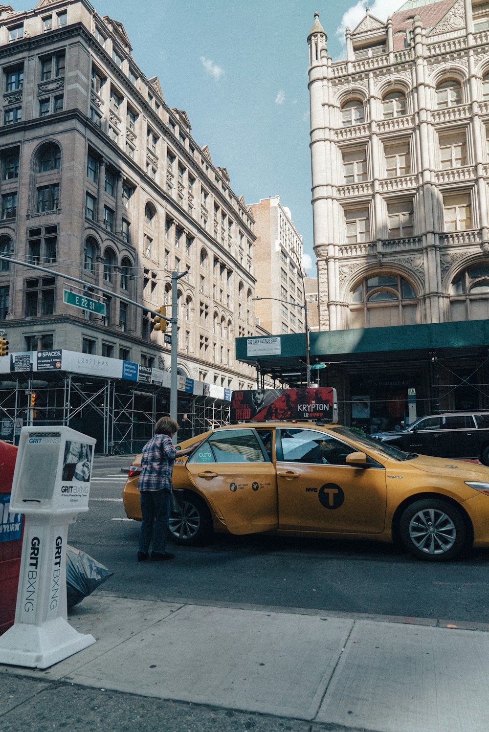 woman standing beside yellow sedan