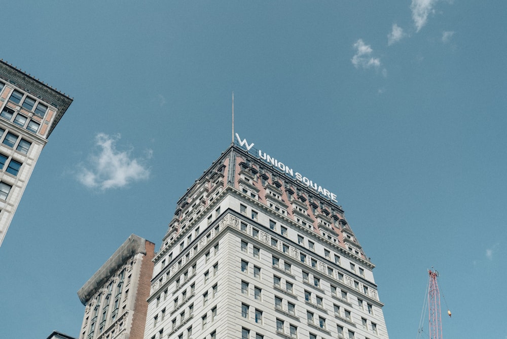 fotografia ad angolo basso dell'edificio in cemento bianco e grigio sotto il cielo blu durante il giorno