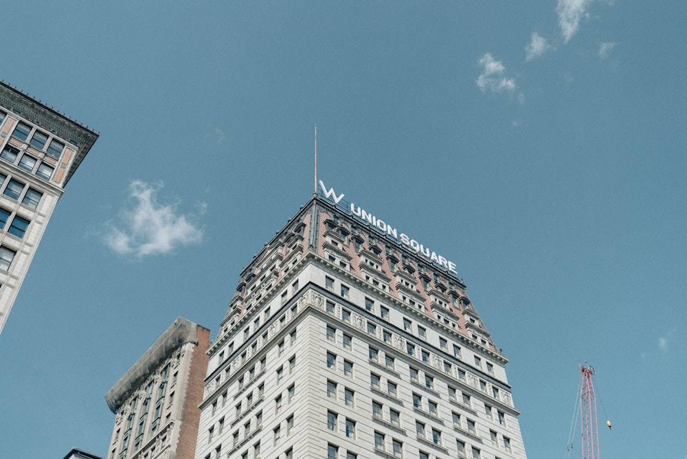 Fotografía de ángulo bajo de un edificio de hormigón blanco y gris bajo el cielo azul durante el día