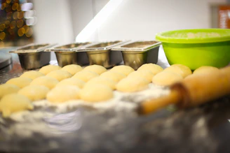 Close-up of fresh vegetables and dough being prepared in a rustic kitchen.