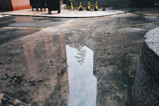 A professional technician inspecting waterproofed concrete surface on a construction site.