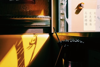 A close-up shot of elegant wooden chopsticks resting on traditional rice paper with a soft focus on a warm dining setting.