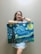 A happy customer holding a recently purchased artwork.