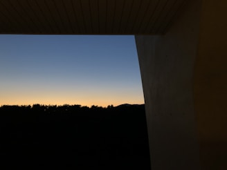 A twilight view of the property’s lofty vertical structure standing against a soft, warm canvas sky.