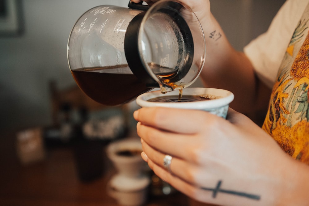 person pouring coffee into cup