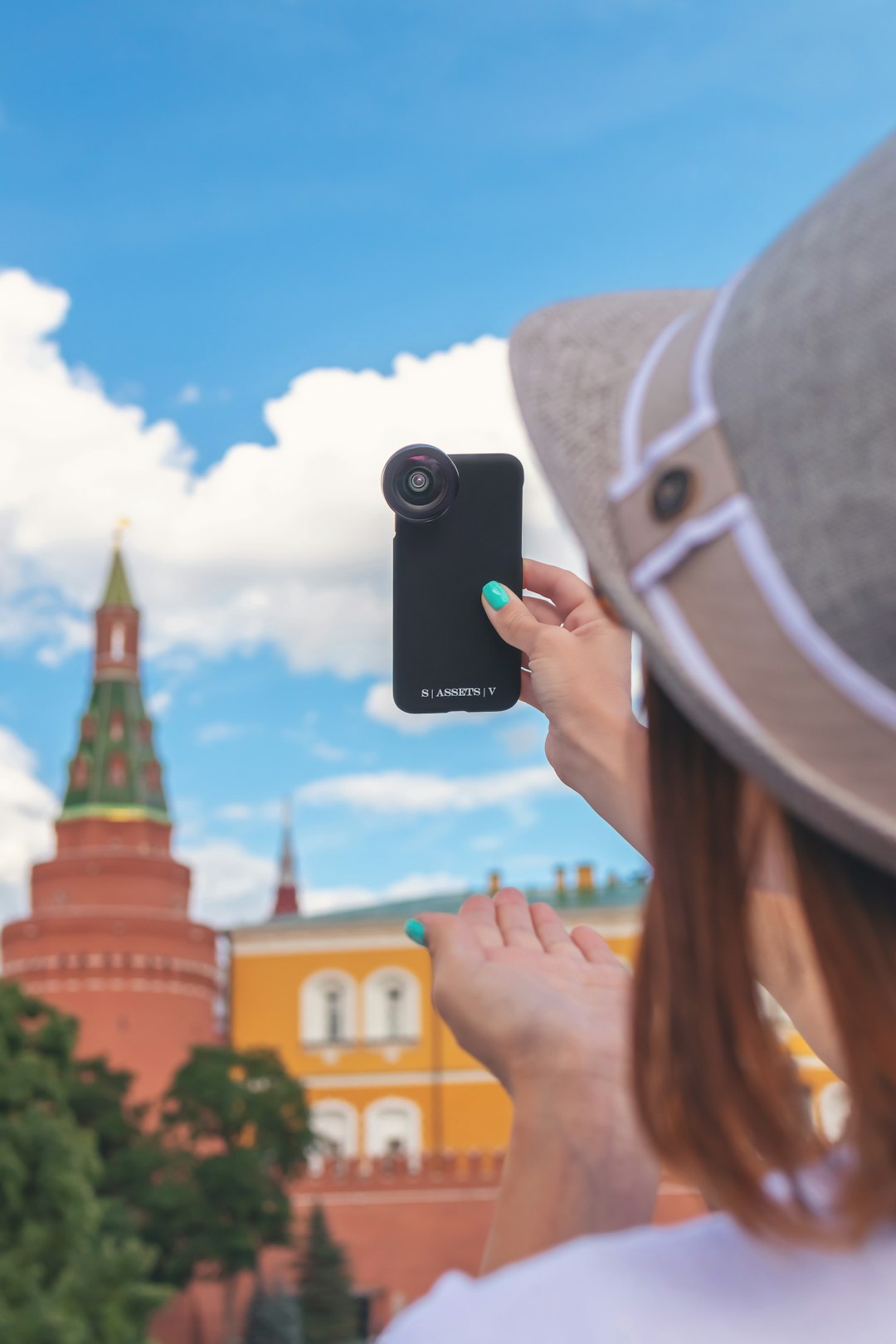 person taking photo on multicolored castle under blue and white skies