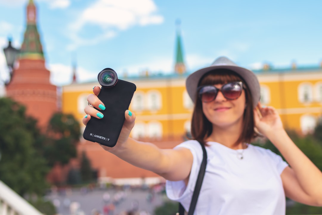 woman holding smartphone with clip lens