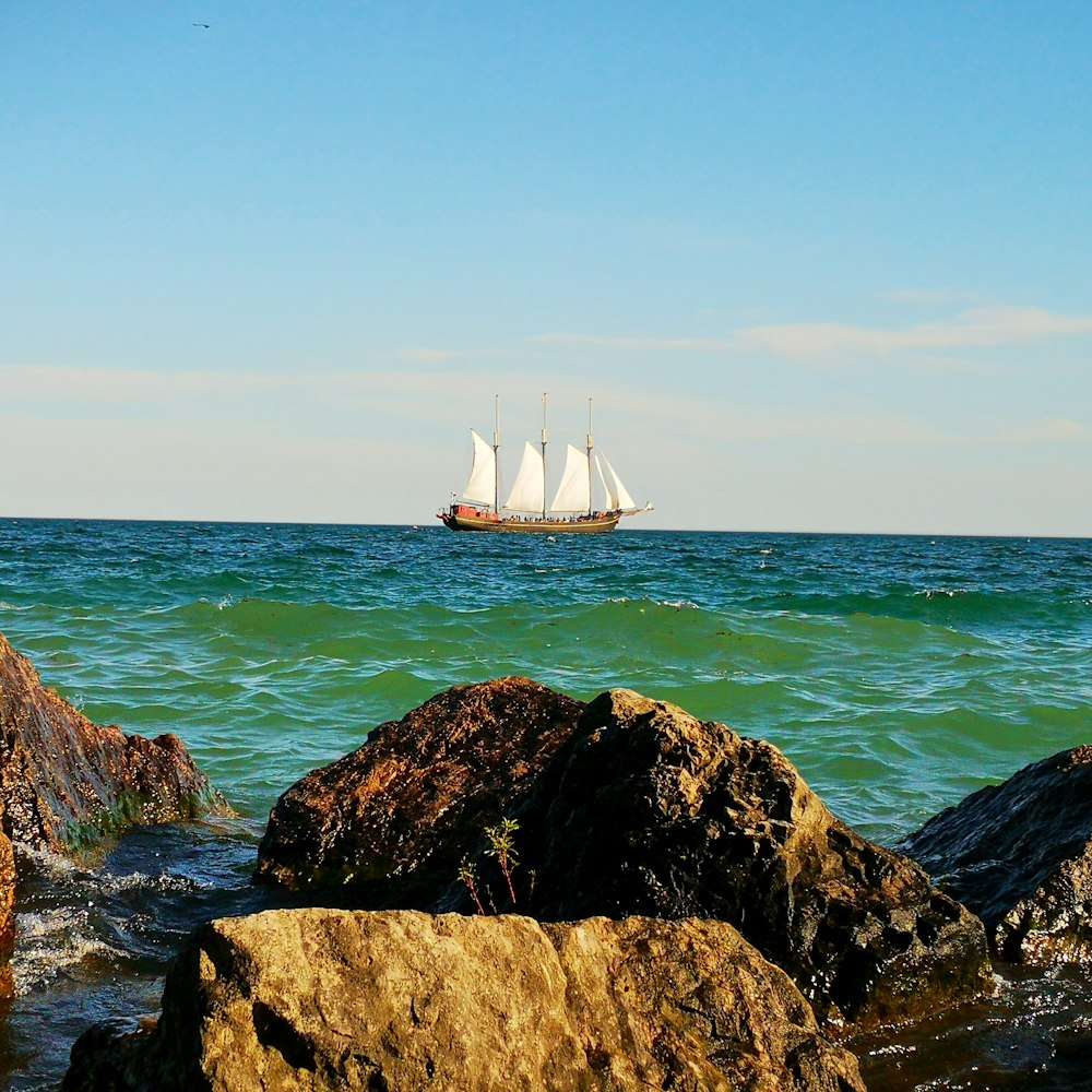 white and brown boat sailing on sea