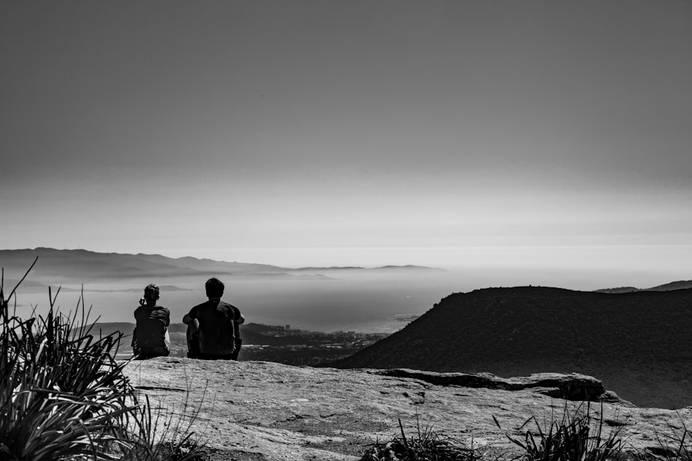 two person siting side by side overlooking sea