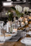 selective focus photography of white flowers beside lighted candle on table