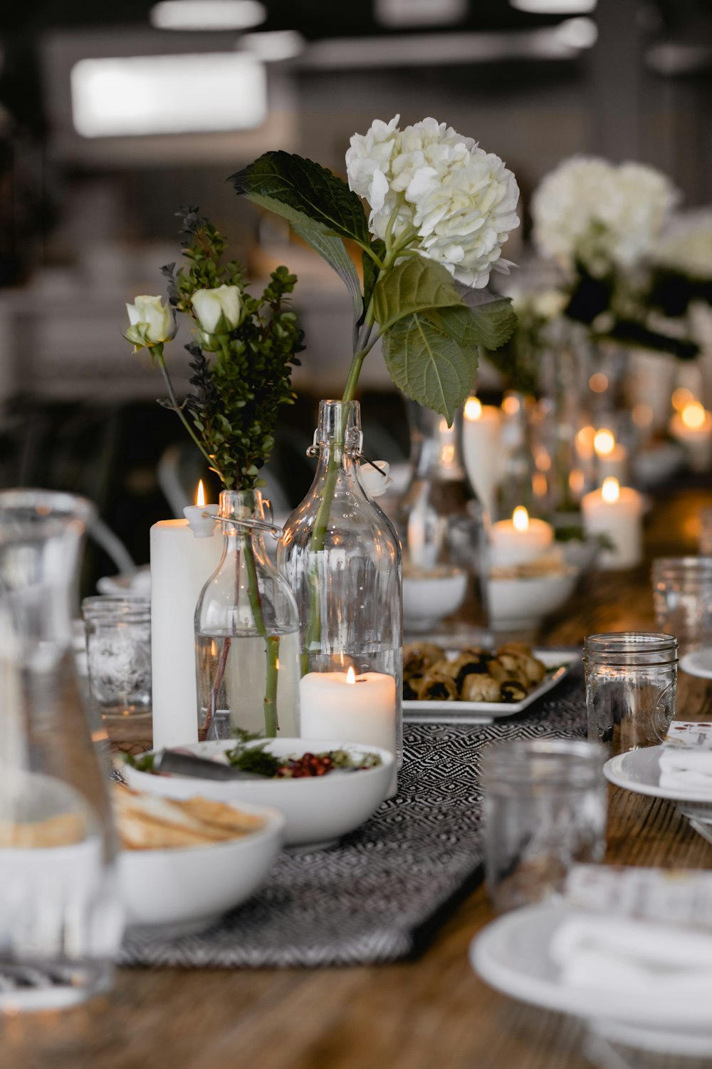 테이블에 촛불이 켜진 옆에있는 흰 꽃의 선택적 초점 사진