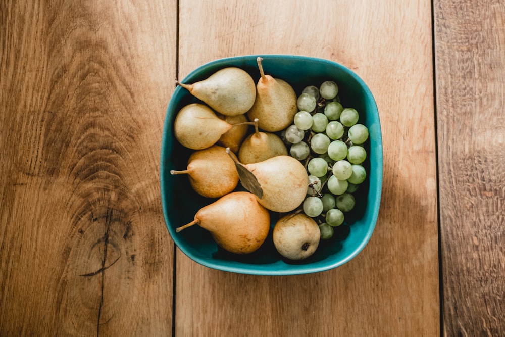 brown pears and grapes inside bowl