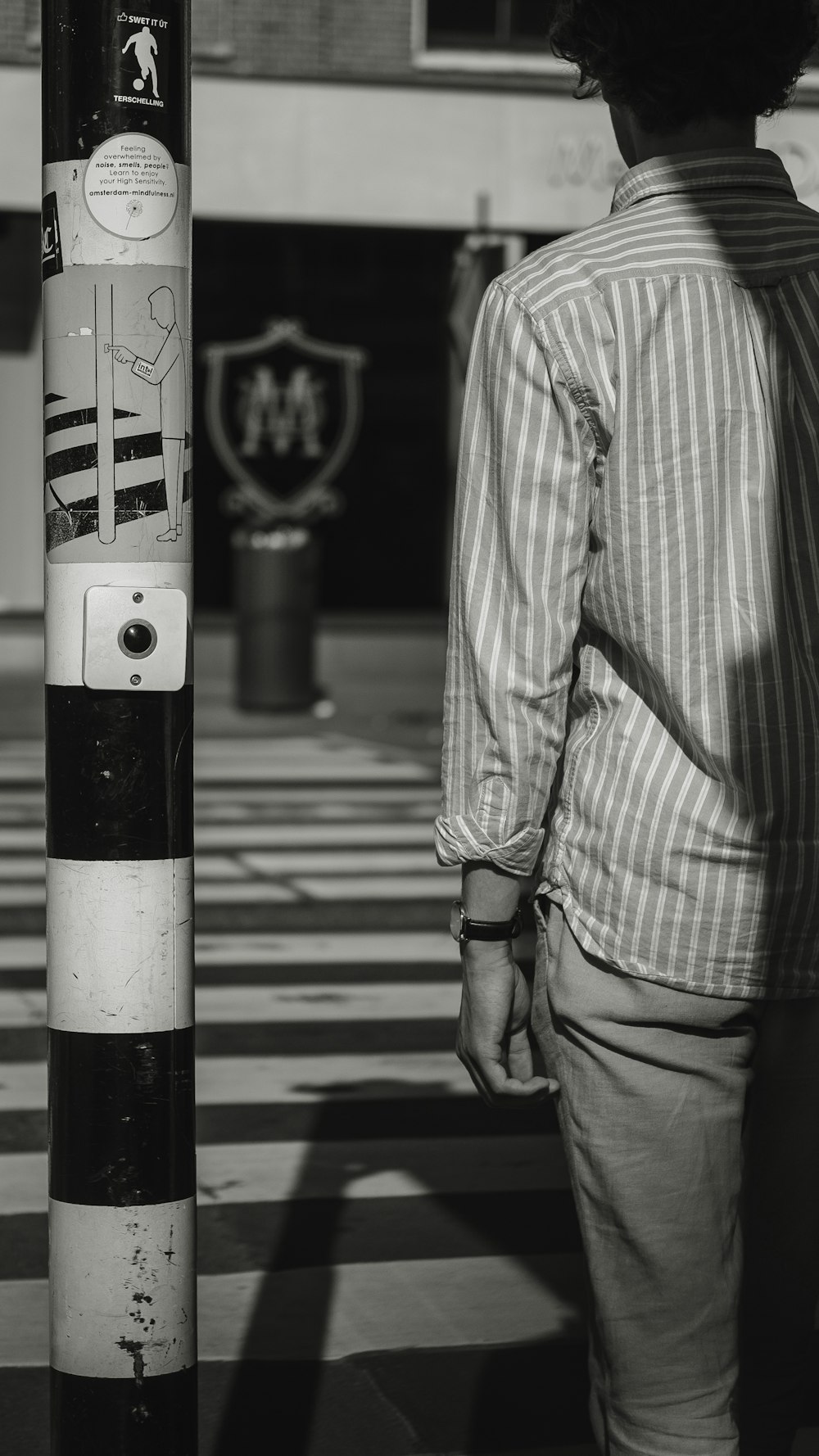 man standing beside street post