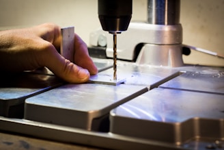 person drilling metal bar