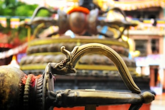 Close-up of a brass utensil handle with engraved patterns.