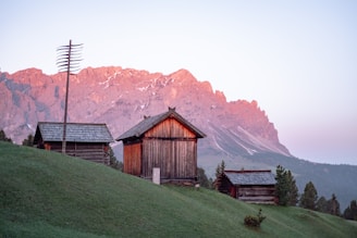 Sunrise over a serene mountain retreat with cozy cabins nestled among tall pine trees