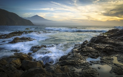 brown rock formation near body of water