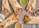 A rustic wooden table serves as the backdrop for a diverse assortment of wraps filled with colorful grilled vegetables, sliced onions, and chunks of seasoned meat or chicken. Small bowls of assorted sauces accompany the wraps, featuring green, brown, and creamy beige hues.