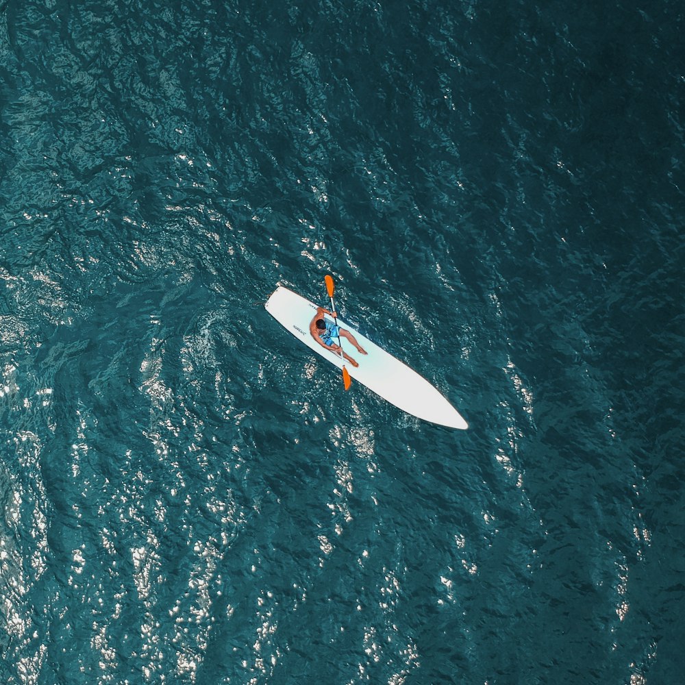 man riding white paddle boat