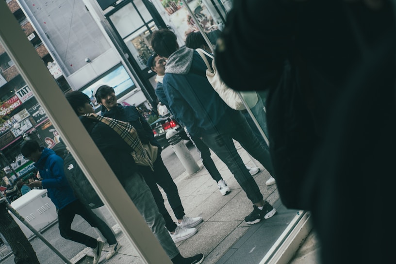 A diverse group of people wearing trendy casual outfits in an urban setting.