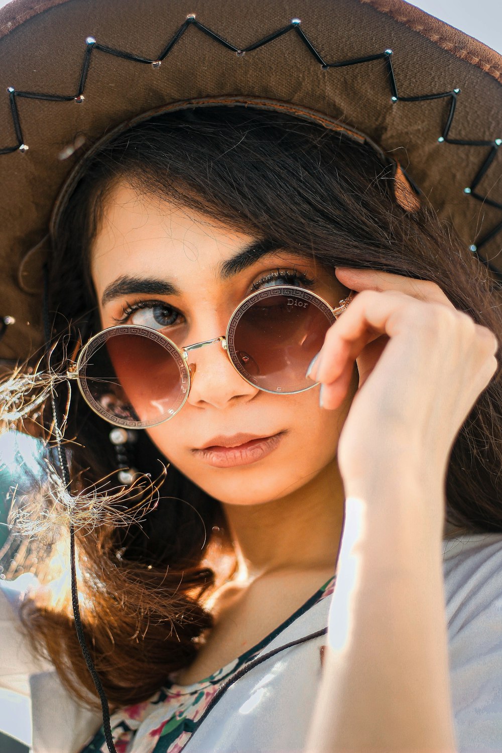 close-up photography of woman holding sunglasses
