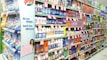 A supermarket aisle filled with various cleaning products, organized neatly on shelves. Promotional sale tags are visible on many items, indicating discounted prices. A promotional stand-up banner on the left features a smiling woman holding clean laundry, with a slogan in Hindi.