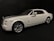 A white luxury car with a sleek design, featuring silver accents and a subtle red stripe. The car is positioned at an angle, showcasing its smooth lines and large wheels against a dark background.