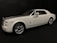 A white luxury car with a sleek design, featuring silver accents and a subtle red stripe. The car is positioned at an angle, showcasing its smooth lines and large wheels against a dark background.