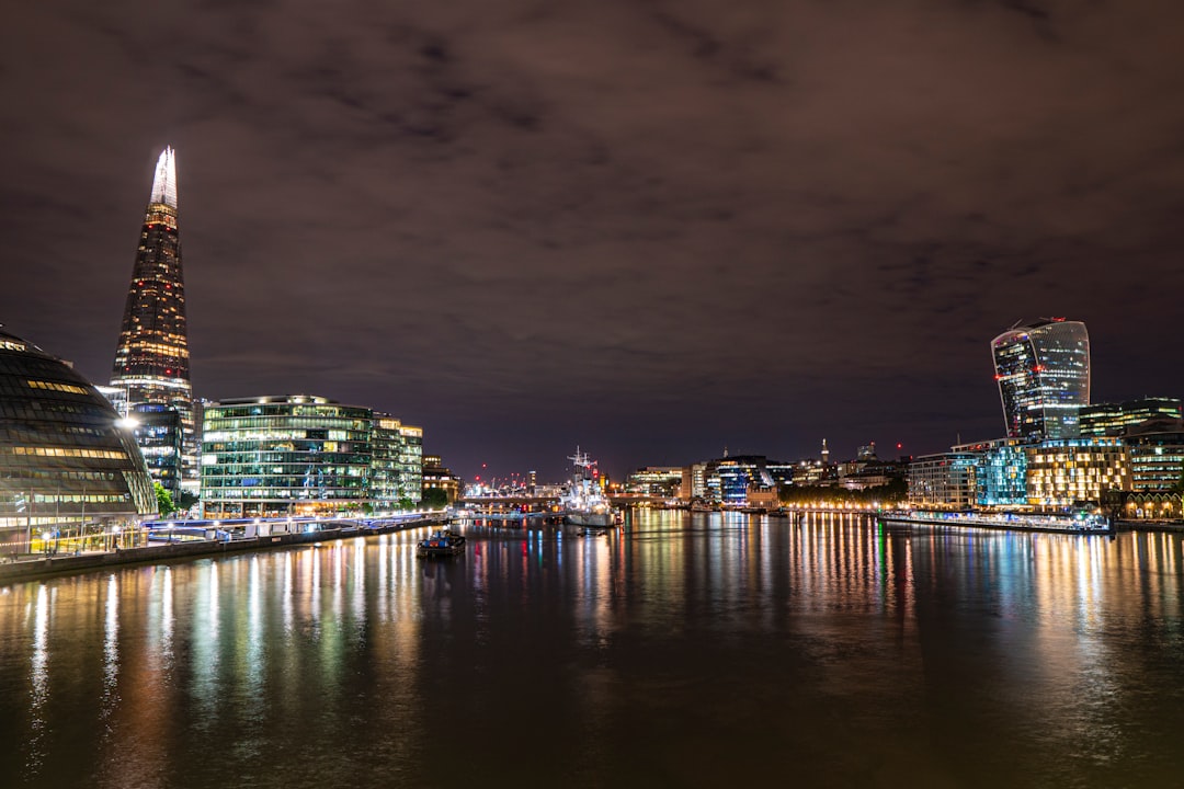 body of water in between lighted city buildings