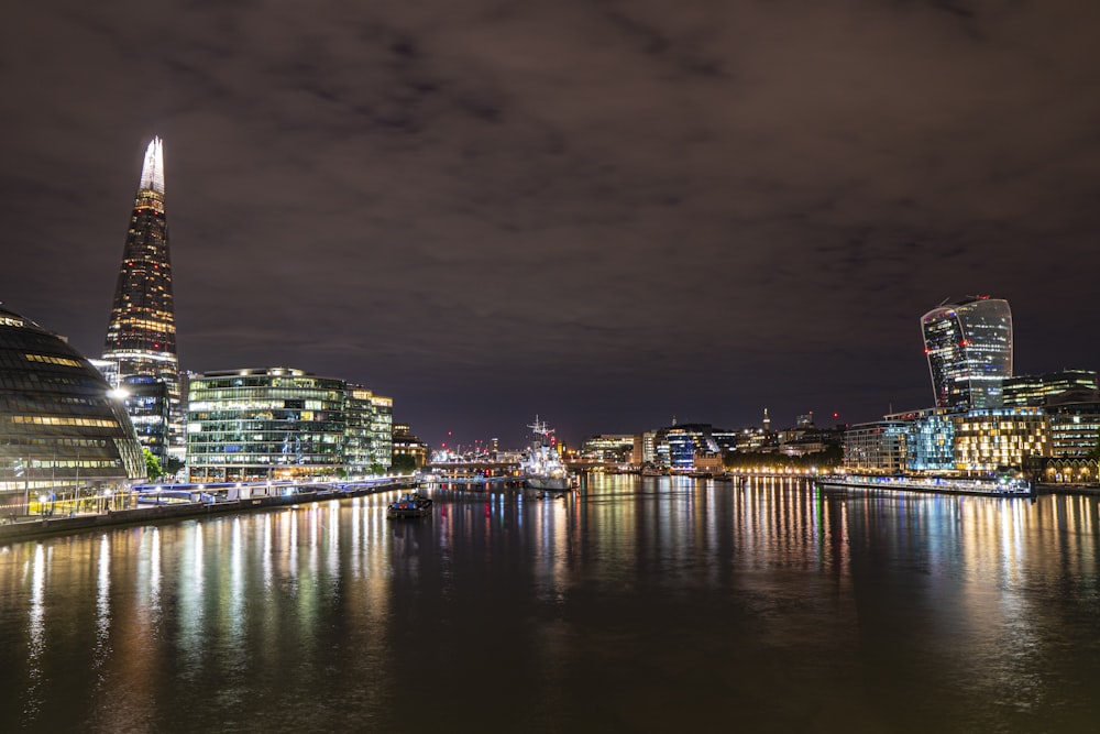 body of water in between lighted city buildings