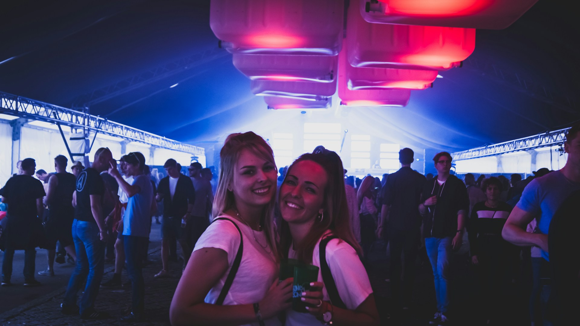 A dynamic event scene with people networking and colorful lighting in a modern venue.