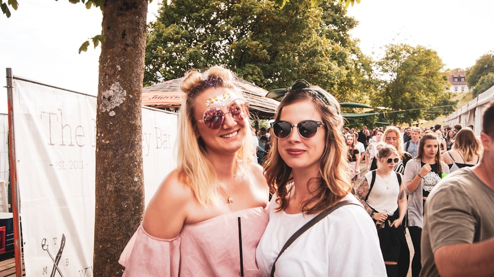 two woman standing near people